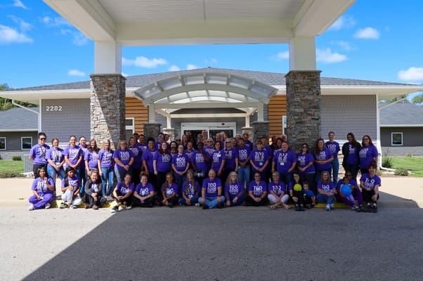 Group photo of staff and residents in front of the facility