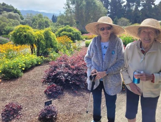 Two residents enjoying a garden with flowers