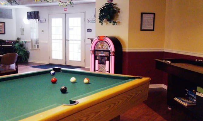 Interior view of an activity room with a pool table and jukebox