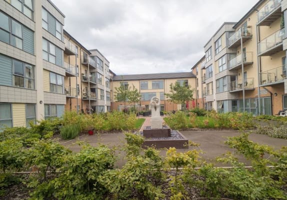View of the courtyard featuring a statue and landscaped greenery