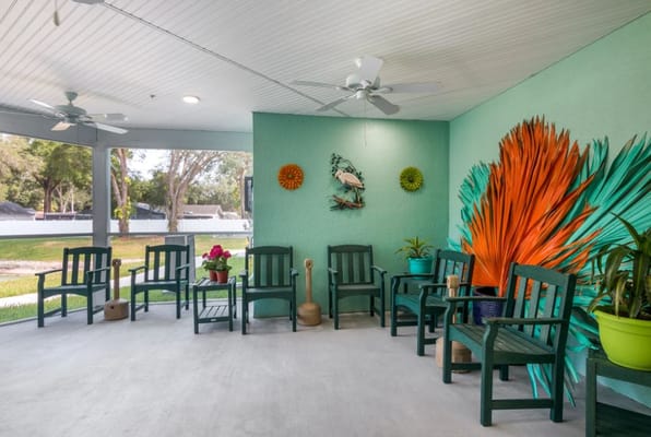 Colorful porch area with seating and plants at Trinity Place Assisted Living