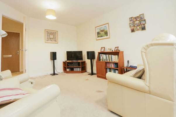 A comfortable living room with a TV, bookshelf, and seating area