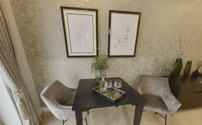 A small living room corner with two chairs and framed artwork.