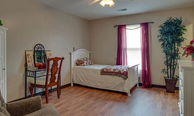 A well-decorated bedroom featuring a single bed, dresser, and a decorative mirror.