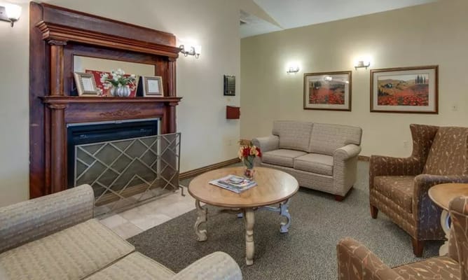 Cozy living room with a fireplace, seating areas, and decor