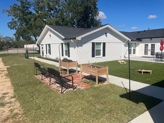 Seating area and garden beds outside Victorious Assisted Living