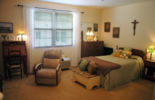 Cozy private resident room with a bed and armchair