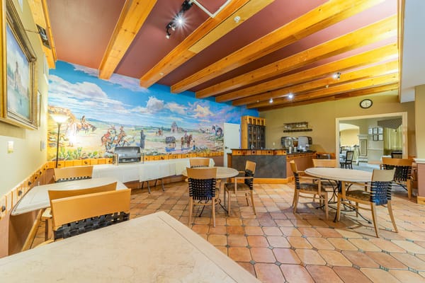 Interior view of the dining area with wooden beams and colorful mural