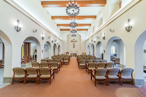 Interior of a chapel with wooden beams and rows of chairs