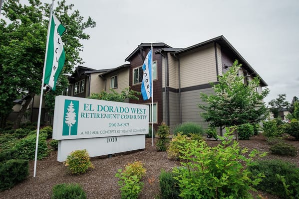 Sign for El Dorado West Retirement Community with lush greenery