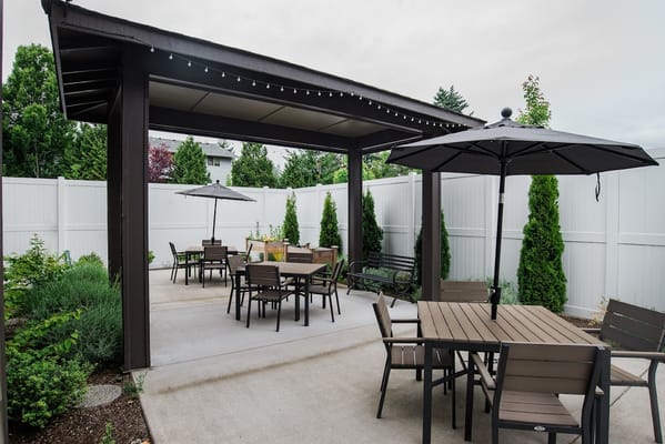 Outdoor patio with tables and umbrellas at Village Concepts of Burien.