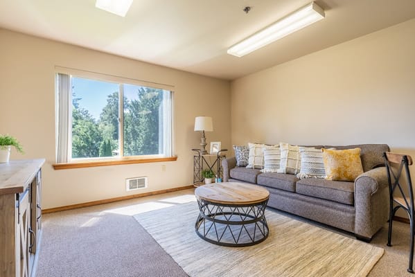 Comfortable living room with a sofa, coffee table, and large window