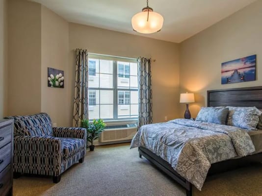 Cozy bedroom with a bed, armchair, and window