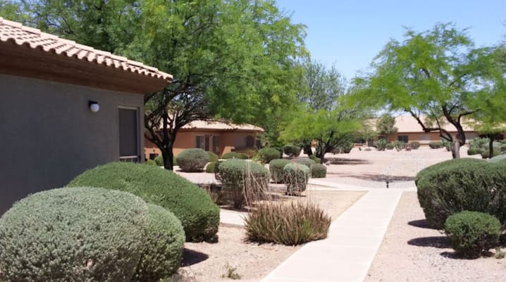 Well-maintained pathway lined with shrubs at Villas by Mary T.