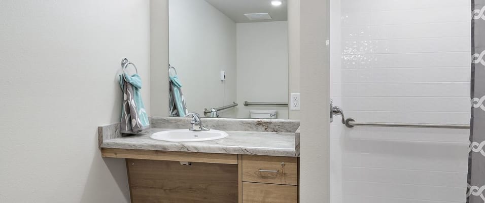 A clean and modern bathroom with a sink and shower.