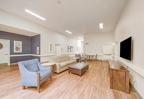 Spacious living room with seating arrangements and wooden flooring