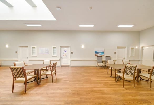 Bright common area with wooden floors and tables