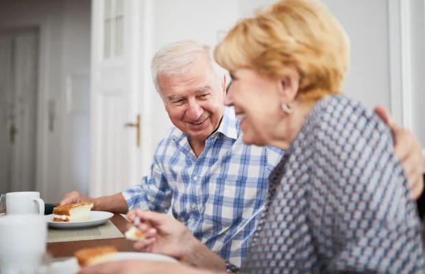 Residents enjoying a meal and conversation at a dining table