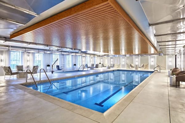 Indoor swimming pool area with lounge chairs