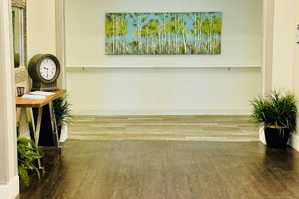 Interior view of a facility hallway with plants and artwork
