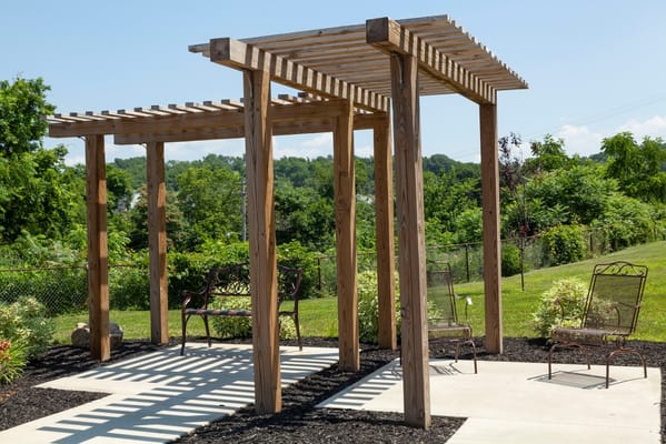 Outdoor pergola with seating in a landscaped area