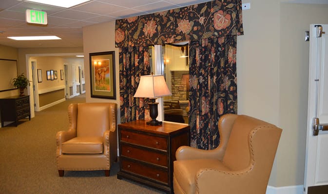 Cozy seating area with armchairs and lamp in a senior living facility