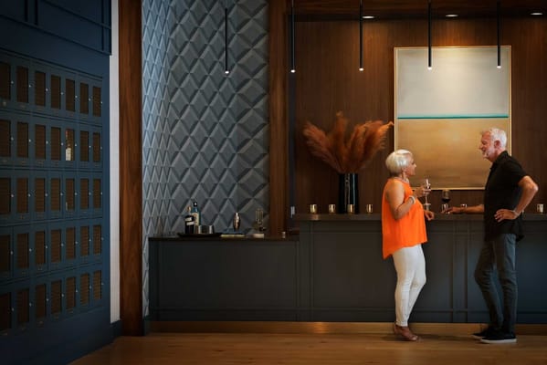 Two residents enjoying drinks in a stylish lobby area