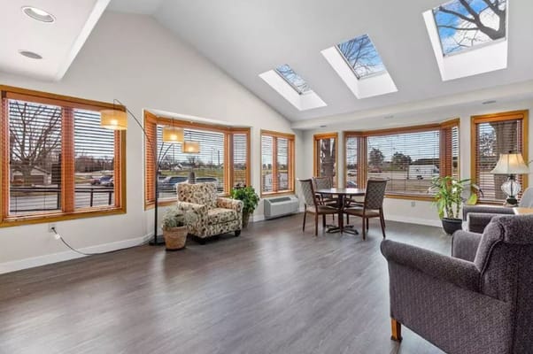 Bright sunroom with large windows and comfortable seating