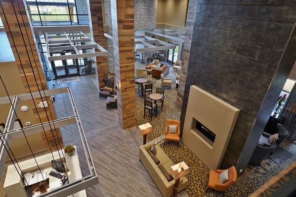 Spacious lobby area with seating and a fireplace.