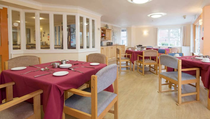 Dining room with red tablecloths and chairs