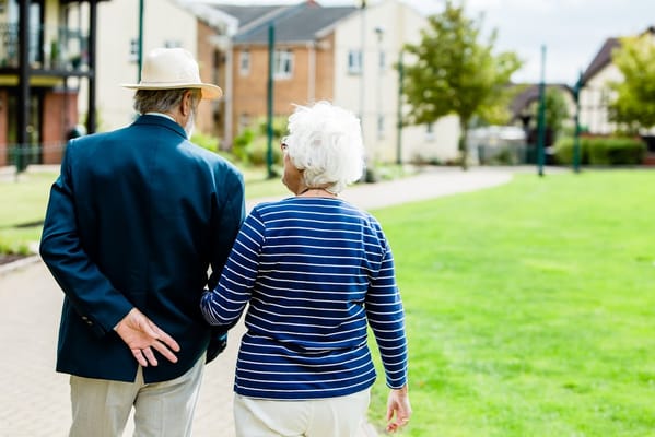 A couple walking together in a grassy outdoor area