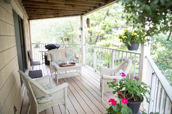 A cozy outdoor patio with seating and flowers