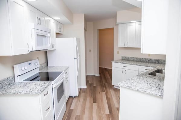 Modern kitchen interior with white cabinets and appliances