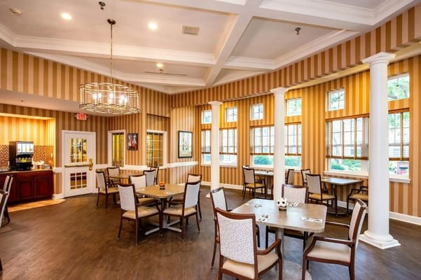 Spacious dining room with tables and chairs in Westlake Woods facility