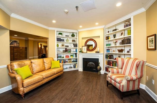 Warm living room with a fireplace, couch, and bookshelf