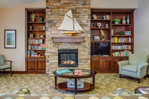Cozy common area with stone fireplace and bookshelves