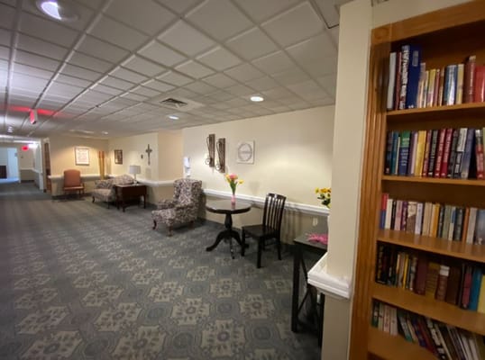 Common area with seating and bookshelf in a hallway