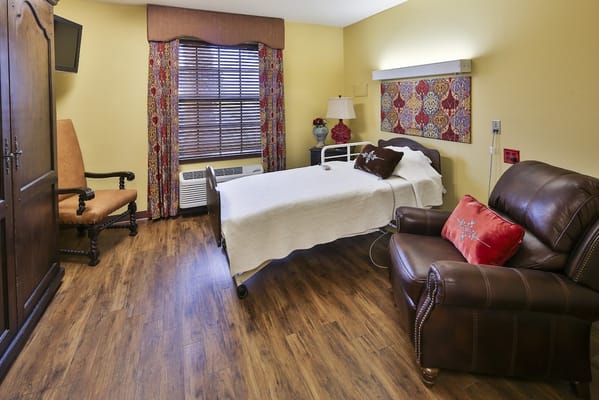 Cozy bedroom with a bed, armchair, and decorative elements.