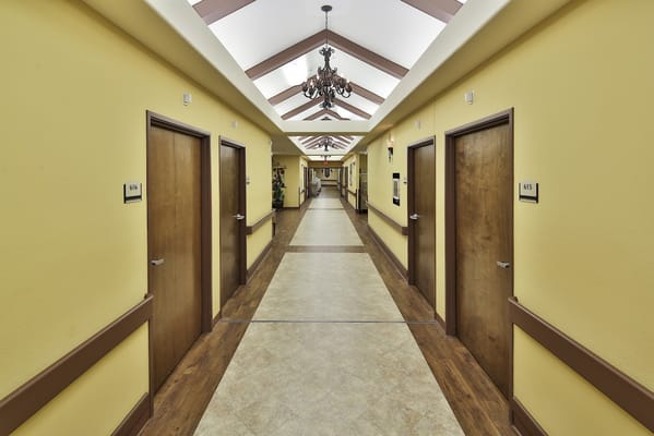 A view of a corridor in Windsor Atrium, with numbered doors and yellow walls.