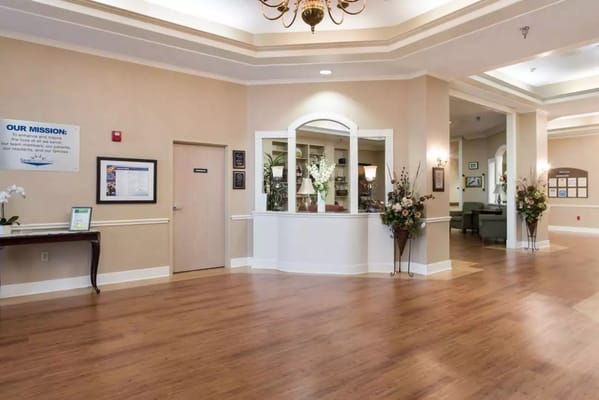 Bright and spacious lobby with a reception area and floral decor.