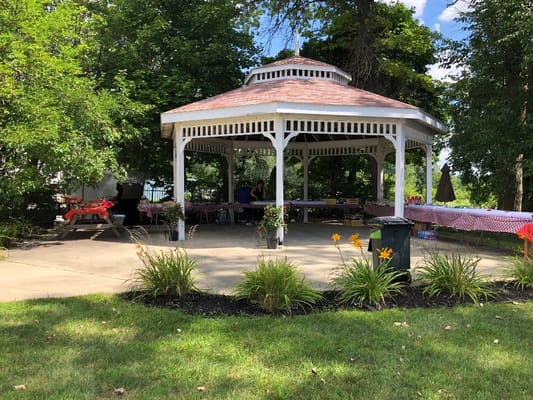 A gazebo in the outdoor space with people sitting around