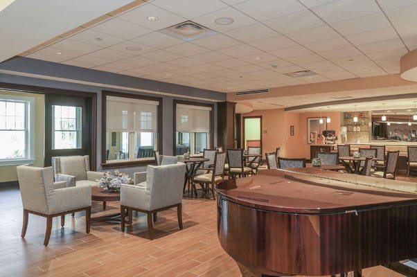 A cozy common area featuring seating and a piano.
