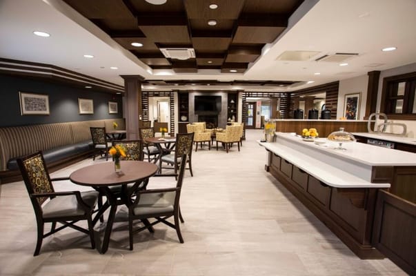 Cozy lounge area featuring tables, chairs, and a kitchenette.