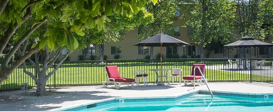 Outdoor pool area with seating and umbrellas