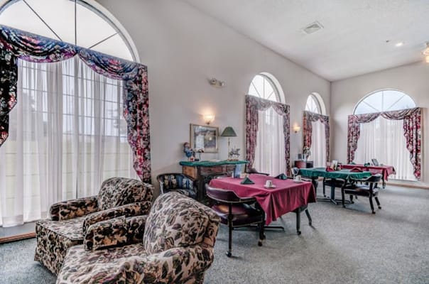 Cozy common area with floral patterned chairs and dining tables