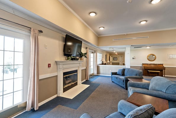 Cozy lobby with seating, fireplace, and TV