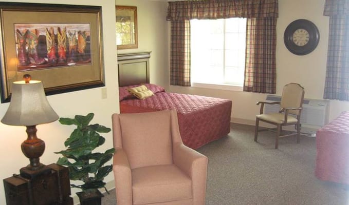 A cozy resident room with two beds and a chair