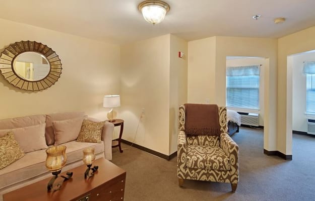 A living room featuring a sofa, armchair, and stylish decor.