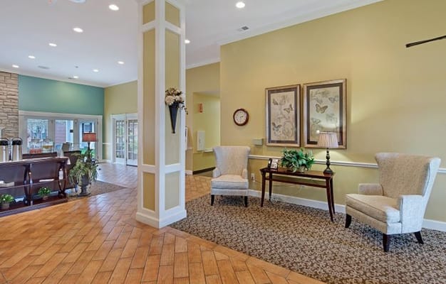 Cozy lobby with two armchairs, a table, and decorative wall art.