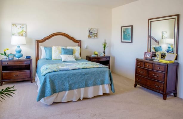 Inviting bedroom with a blue quilt and wooden furniture